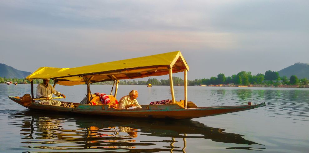 One person enjoying Shikara ride with Shikara owner in Dal Lake, Srinagar in Kashmir Tour Package.